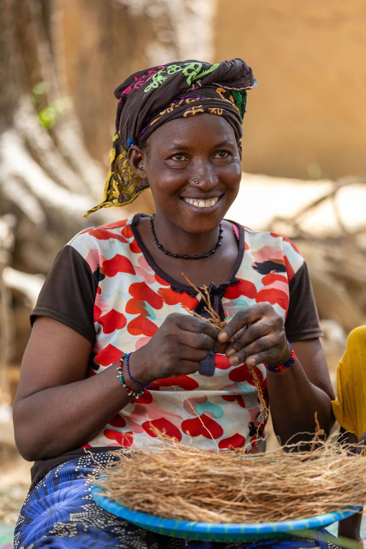 Femme malienne souriante tressant et préparant les racines de khamaré vétiver
