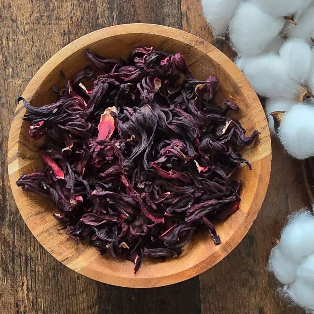 Calices d’hibiscus sabdariffa séchées riches en antioxydants dans un bol en bois africain