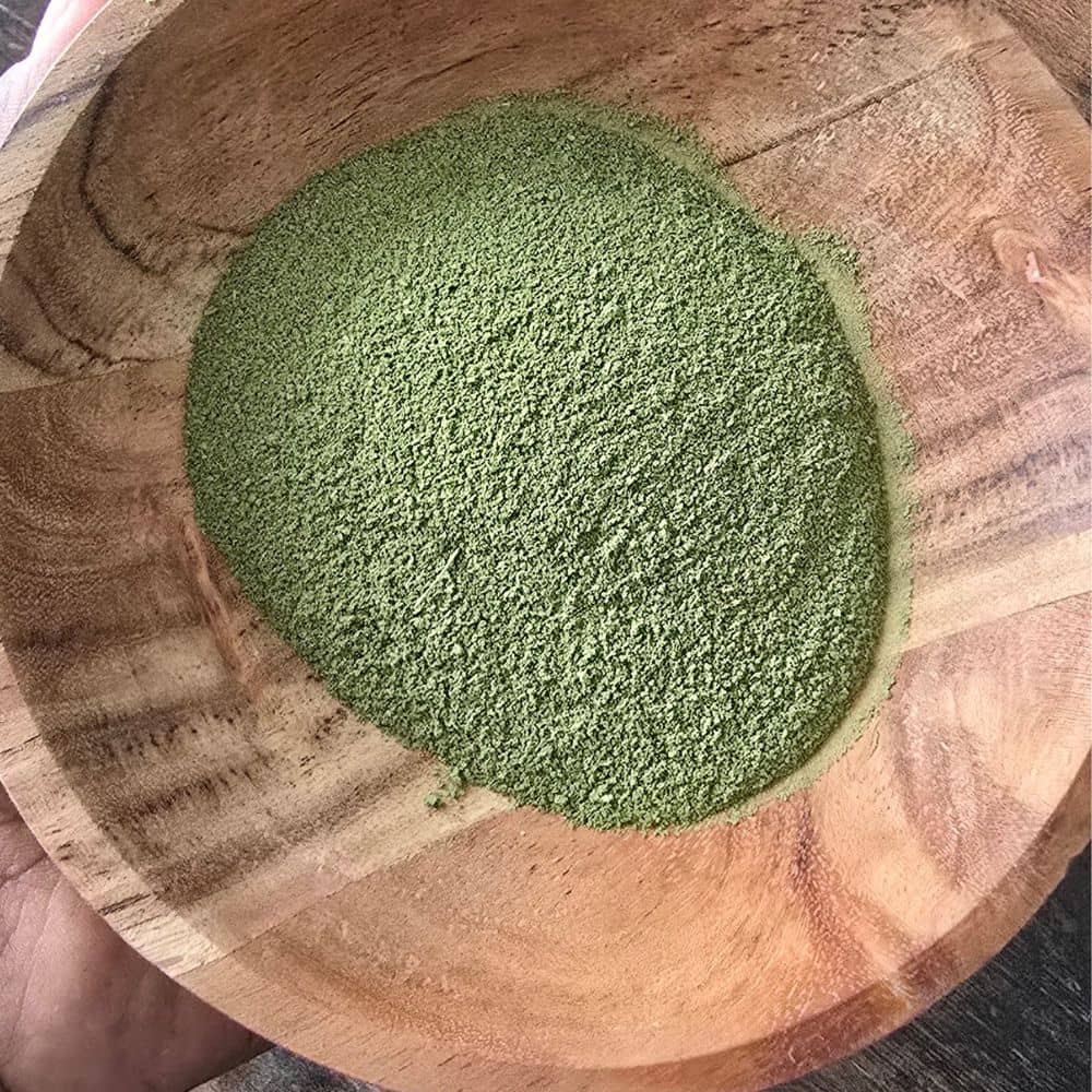 Poudre de Moringa oleifera riche en nutriments présentée dans un bol en bois