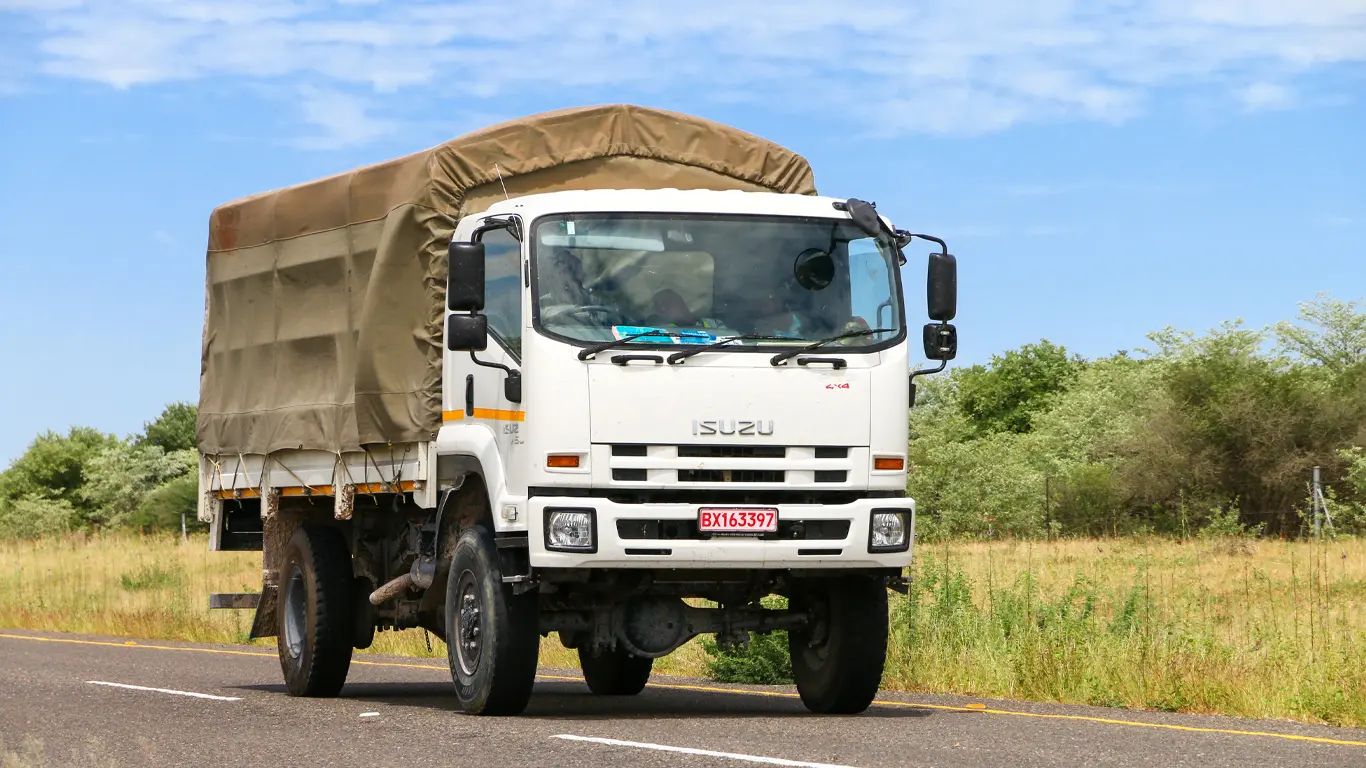 Camion de la marque ISUZU qui transporte de la marchandise sur une route en afrique